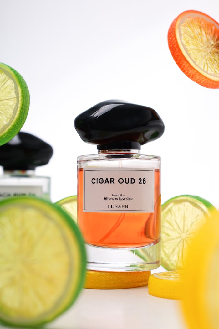 Luxurious Cigar Oud 28 perfume bottle surrounded by vibrant citrus slices, exuding freshness.